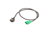 Automotive temperature sensor with black cable and green electrical connector.