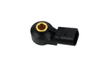 Black automotive electrical sensor connector with brass terminal on white background.