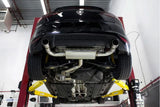 Black Volkswagen on lift showing dual exhaust system and undercarriage in auto repair shop