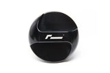 Black automotive gear shift knob with white logo on a white background