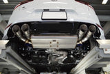 Custom quad exhaust system installed on a white European performance vehicle.