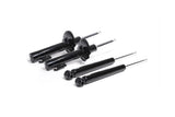 Set of four black automotive shock absorbers for German vehicle suspension repair.