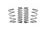 Set of four silver metal automotive coil springs for vehicle suspension systems.